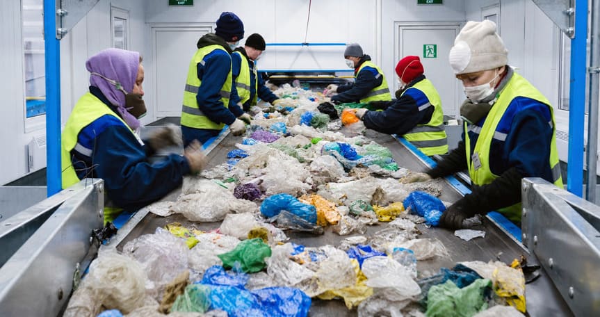 Workers sorting polypropylene bags at a recycling facility